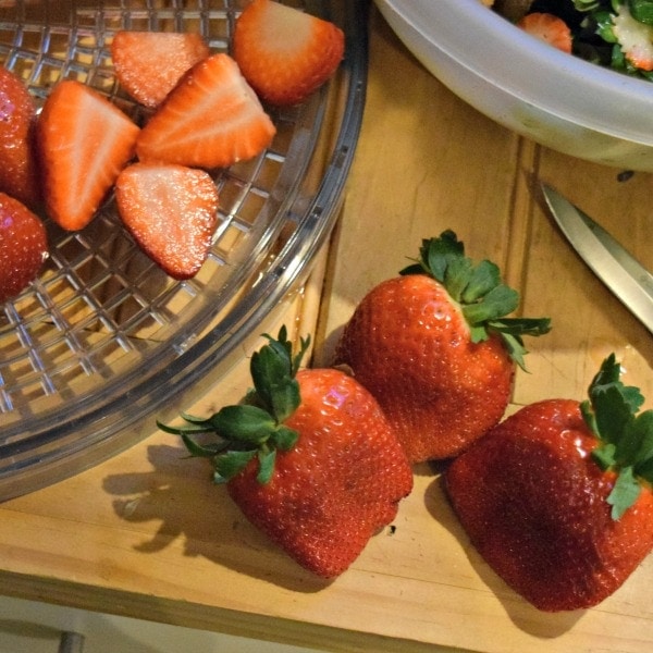 3 large strawberries laying on a wood surface