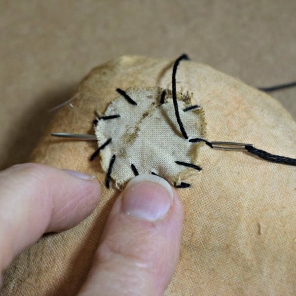 Rustic Fall Pumpkin Craft - very close up image o fingers stitching with needle and thread