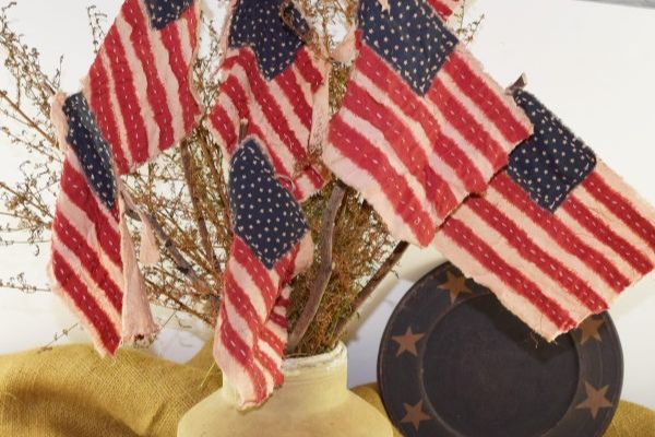 handmade 4th of July red white and blue flags in an old crock