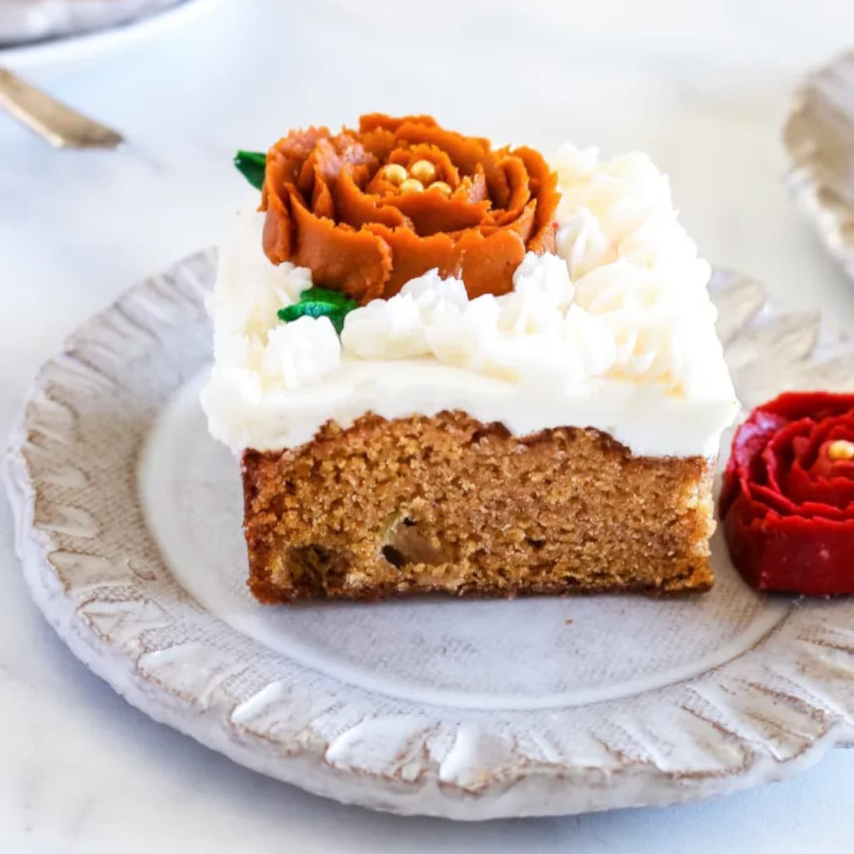 from scratch pumpkin cake with an orange flower on top made of icing