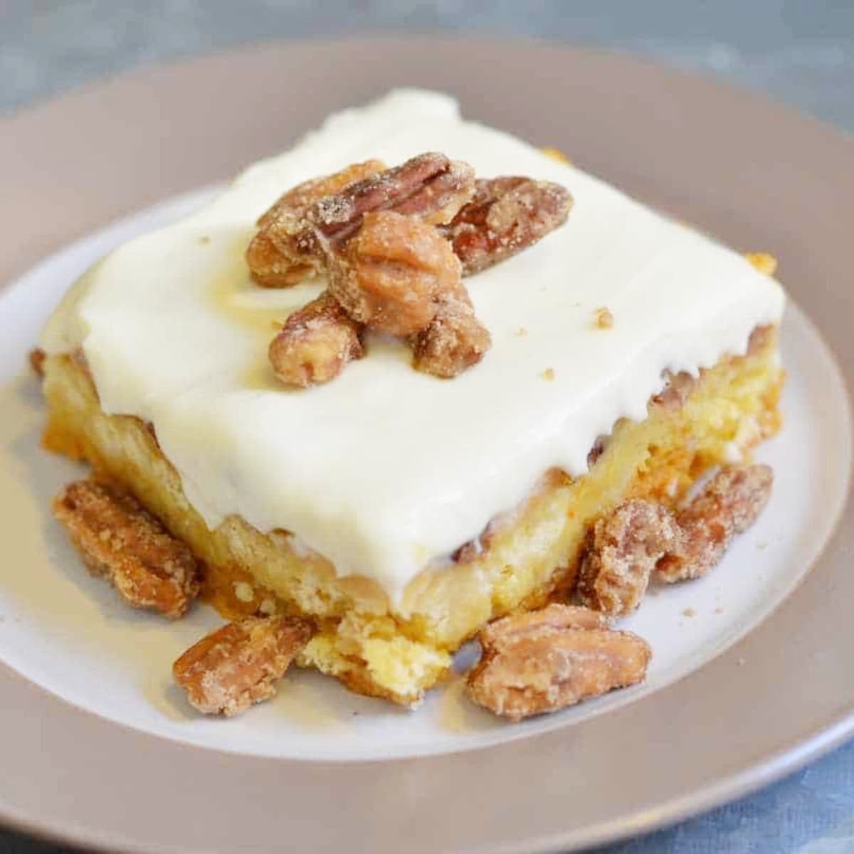 pumpkin crunch cake precipe on a white plate with nuts on top