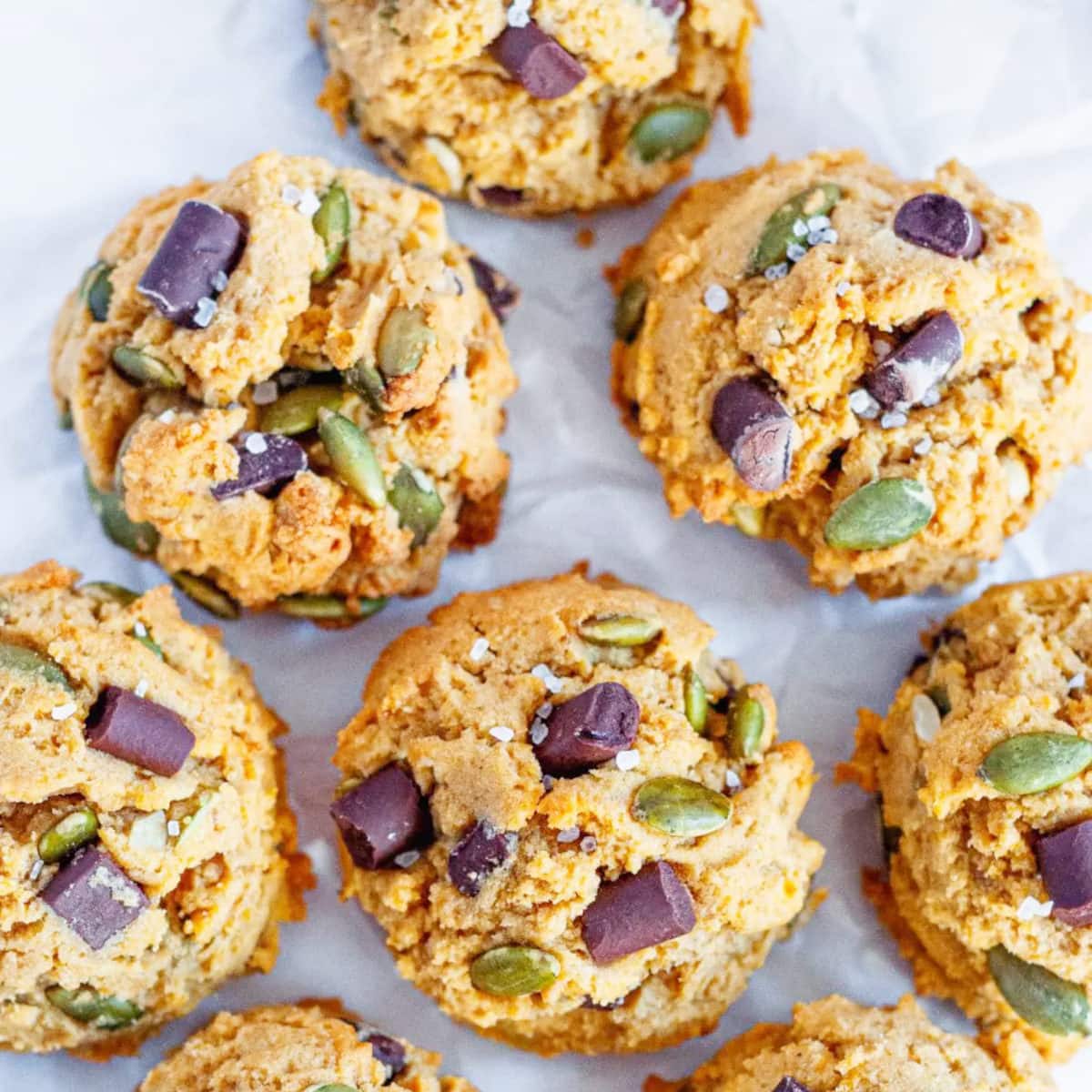 healthy pumpkin cookies with pumpkin seeds and chocolate chips on a white paper