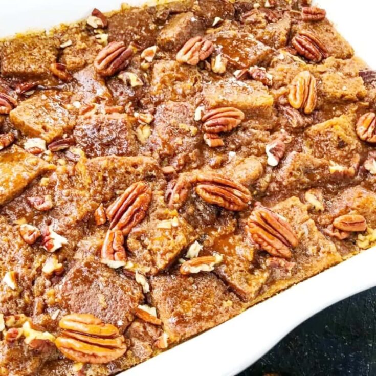 a delicious pumpkin bread pudding topped with pecan halves in an attrative white dish