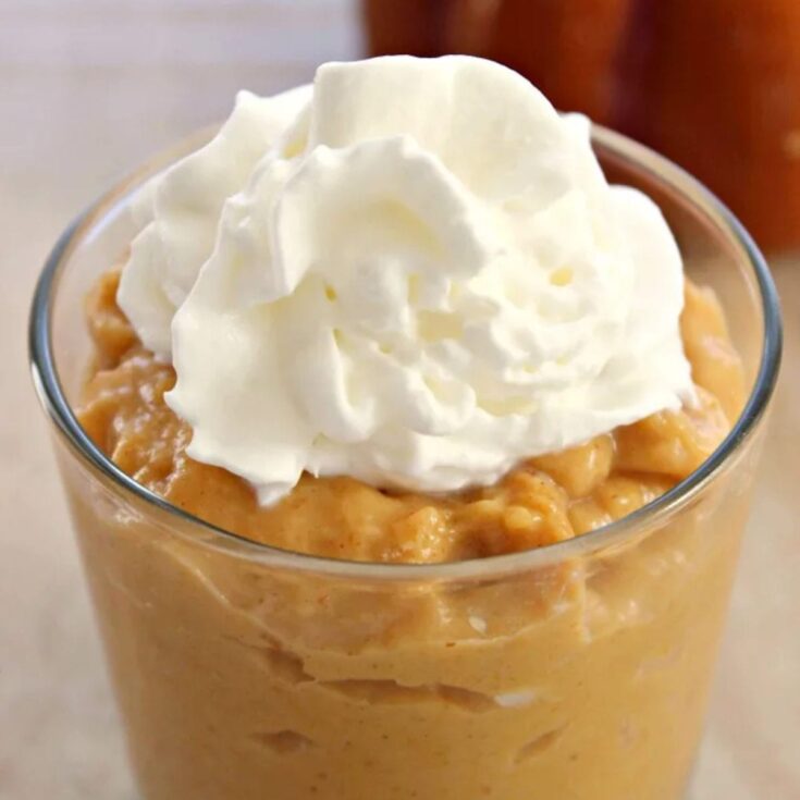 creamy orange pumpkin pudding in a cute glass topped with whipped cream