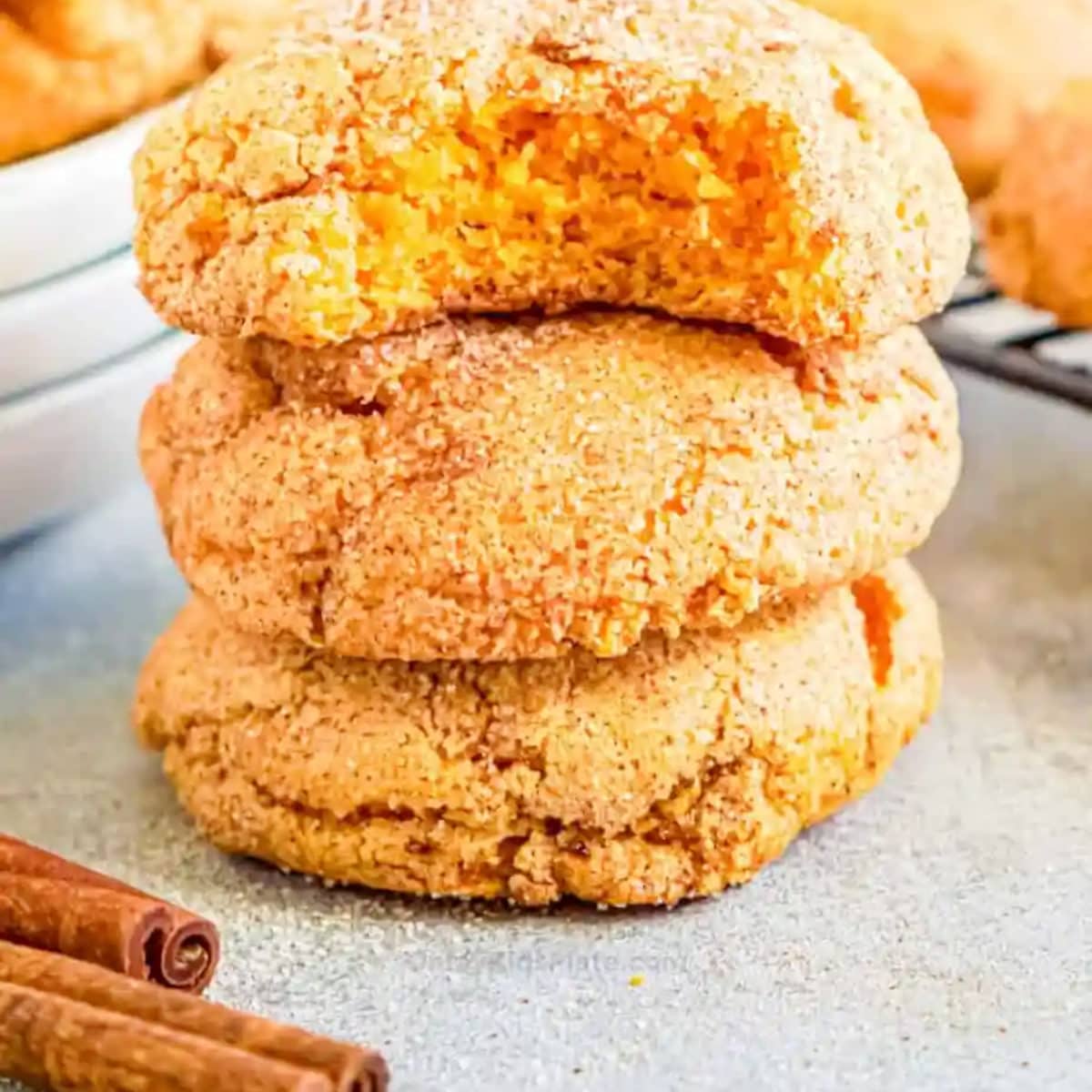 stack of pumpkin snickerdoodle cookies near cinnamon sticks