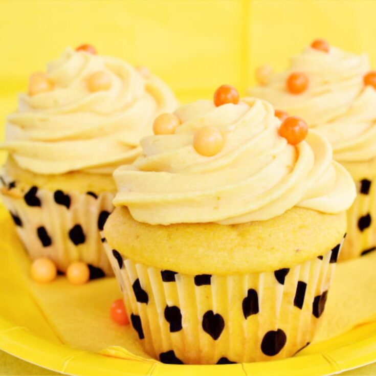 pumpkin cupcakes with yellow cream chees frosting with orange candies on top