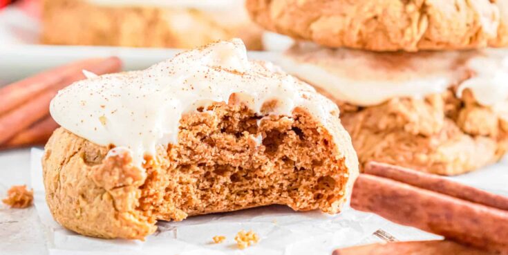 a pumpkin cookie made with cake mix with a white cream cheese frosting