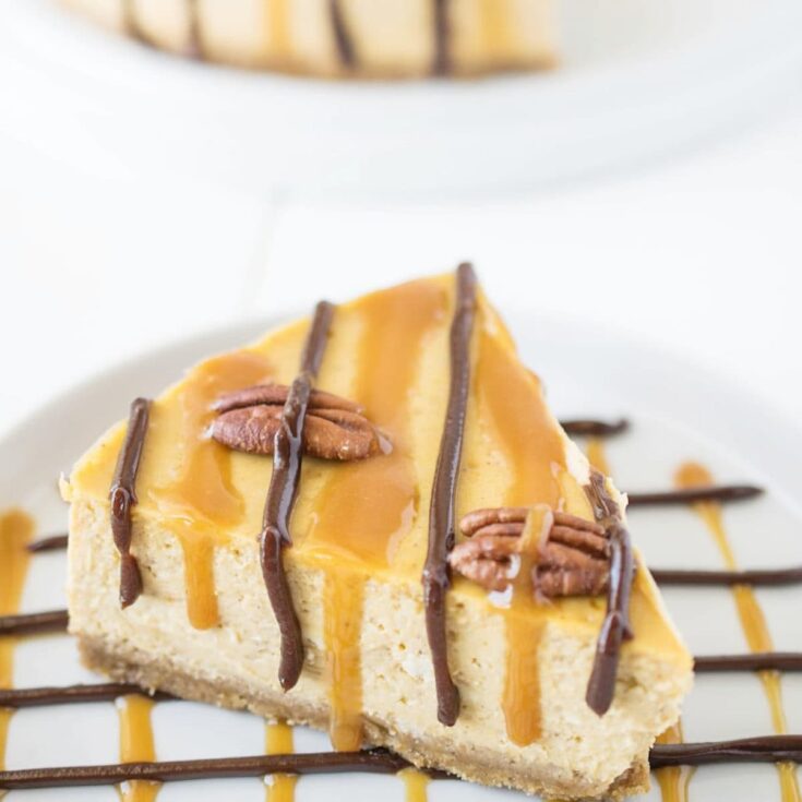 slice of pumpkin cheesecake with pecans, caramel, and chocolate on top