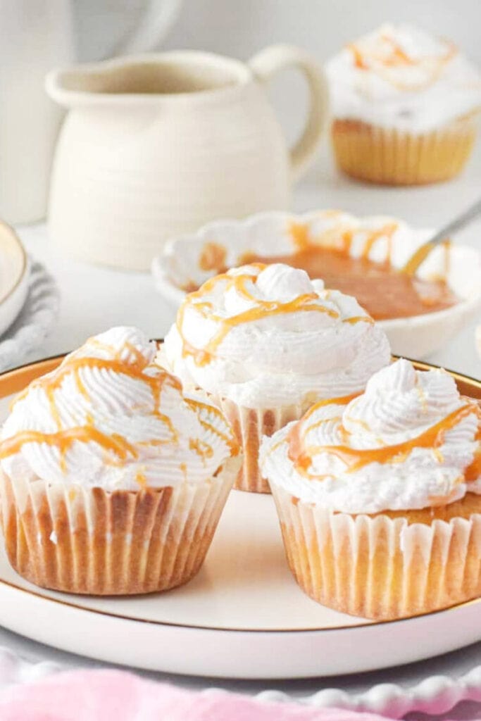 three pretty pumpkin cupcakes with caramel streusel on top