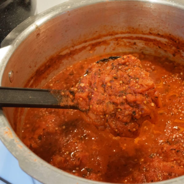 pizza sauce simmering on the stove to thicken it