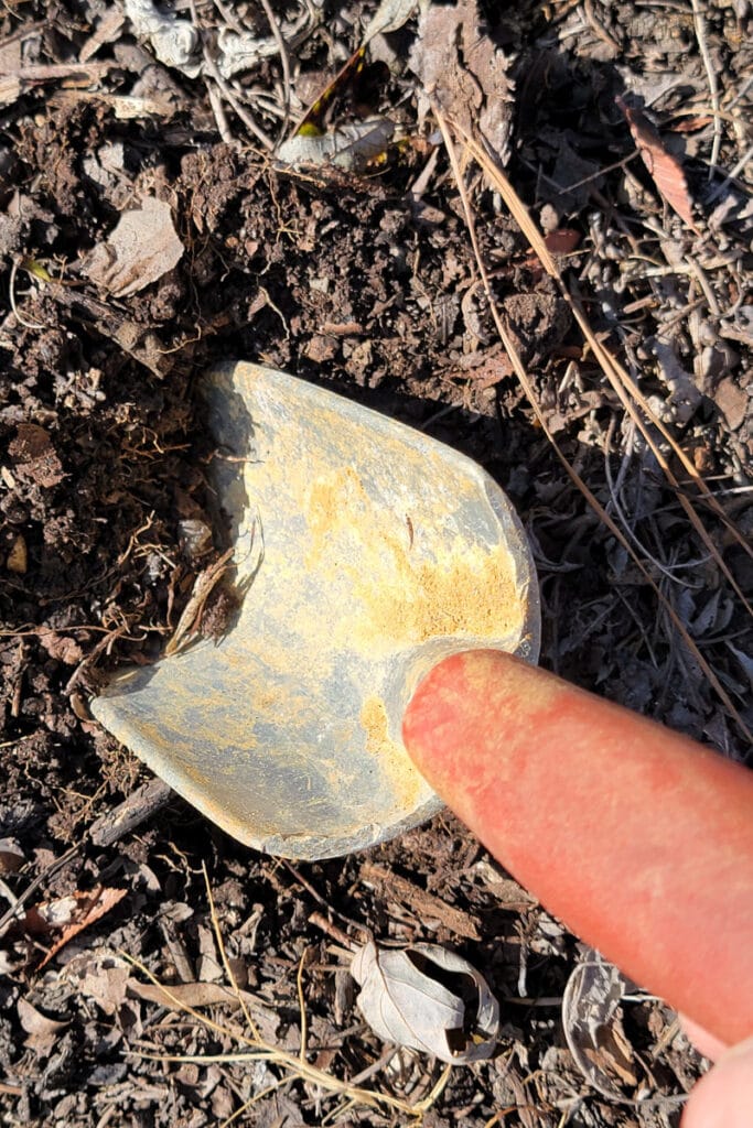 garden trowel with red grip handle in the soil